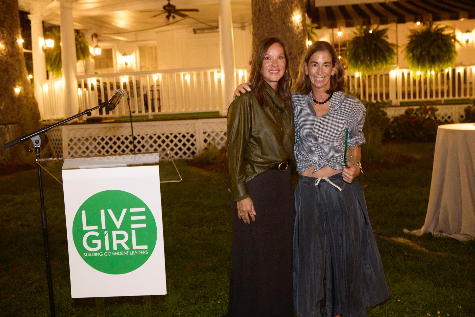 Sheri West and Claire O'Hare celebrating together beside the LiveGirl lectern
