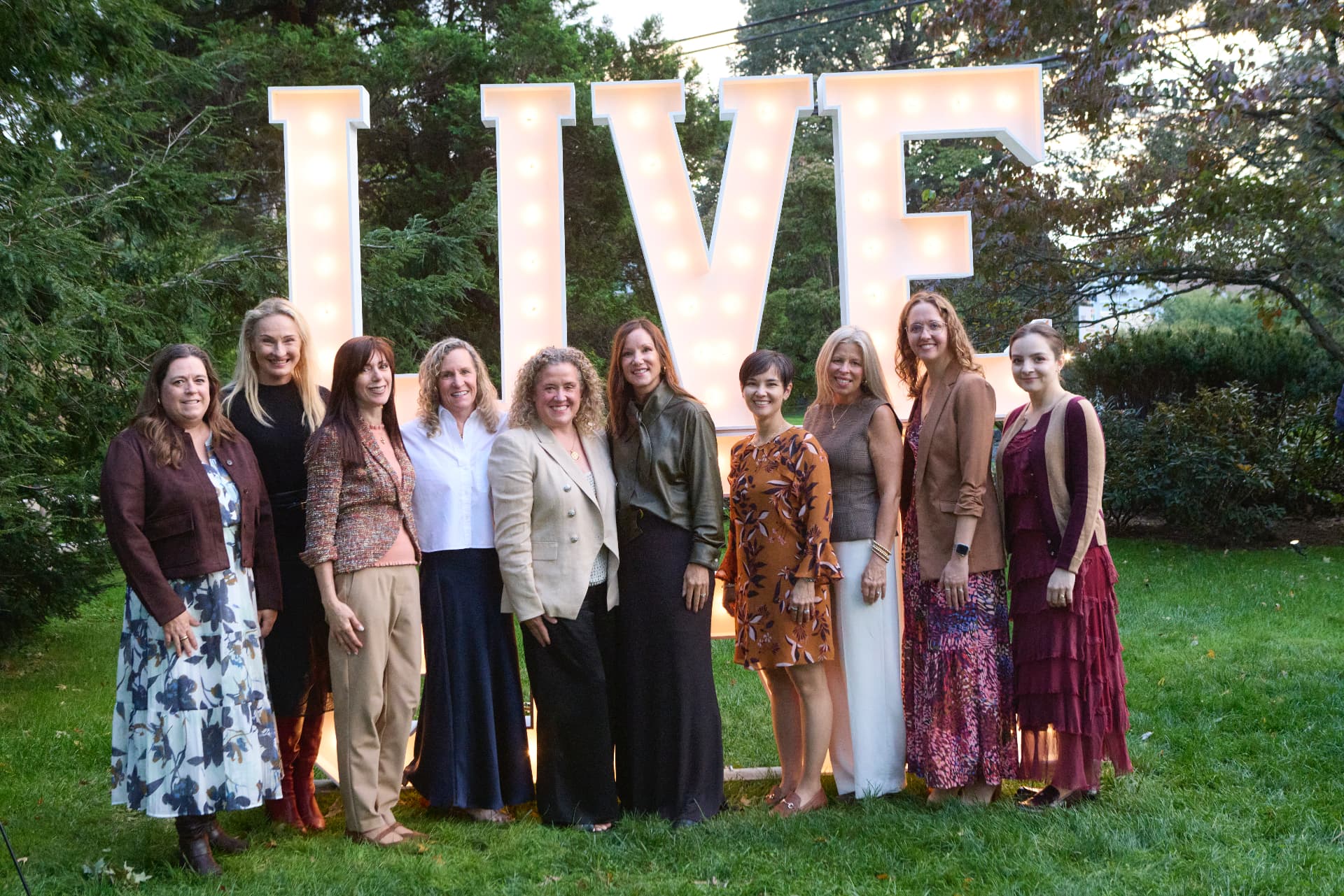 Guests from TIAA beneath the glowing LiveGirl letters