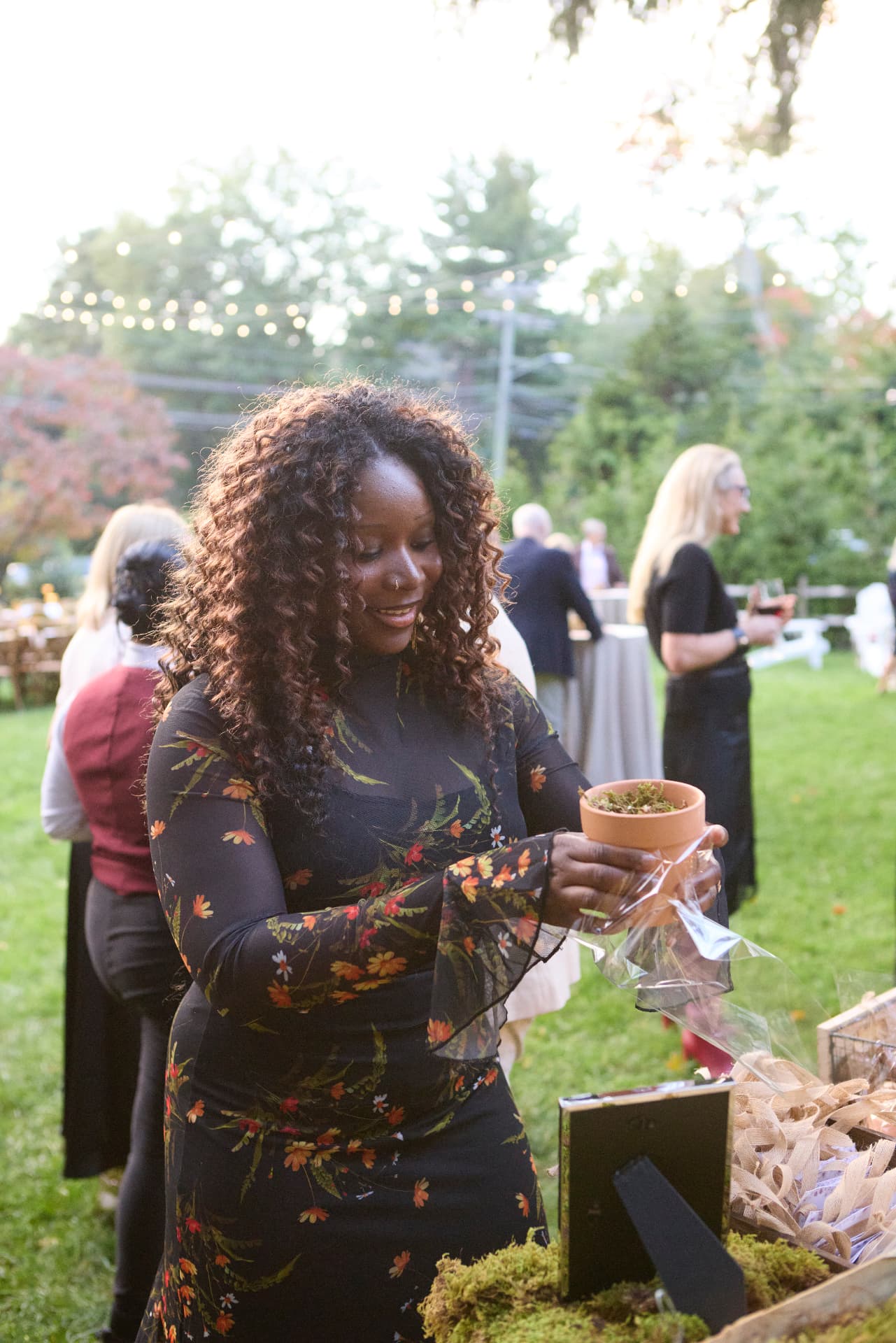 A guest holding a newly potted and wrapped bulb