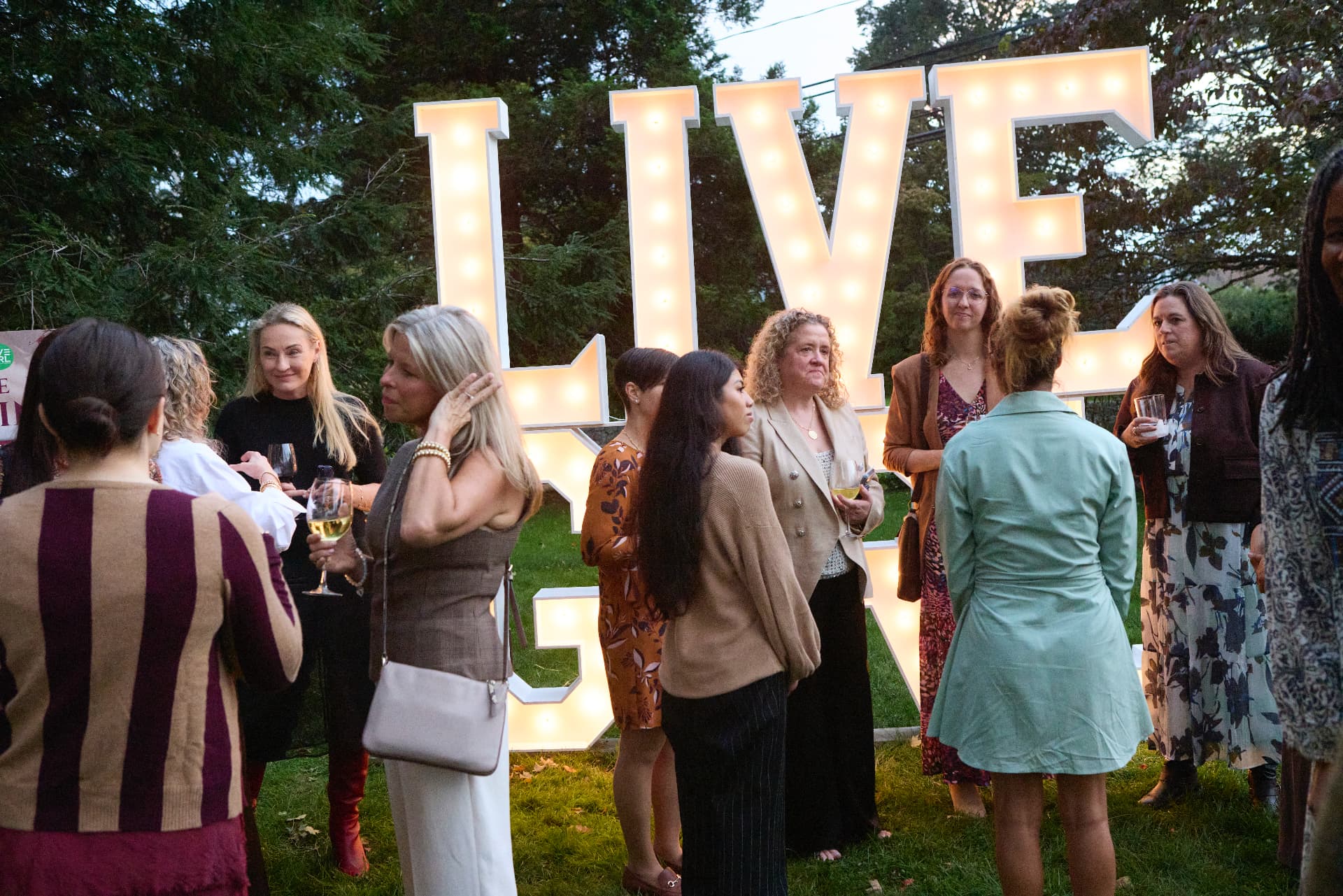 Guests mingling beneath the LIVE letters