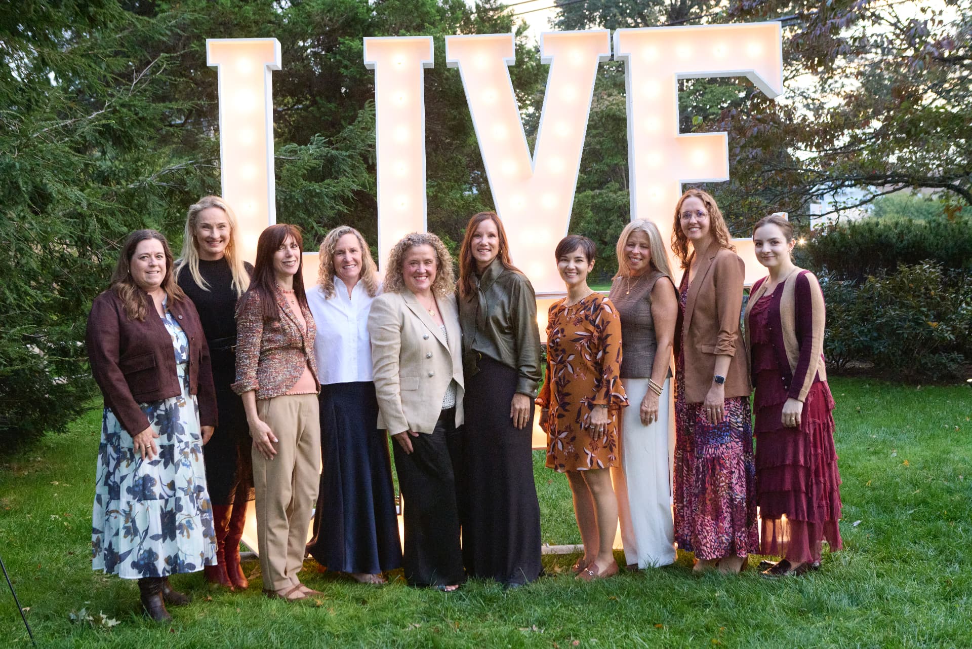 The LiveGirl team in front of the glowing LIVE letters