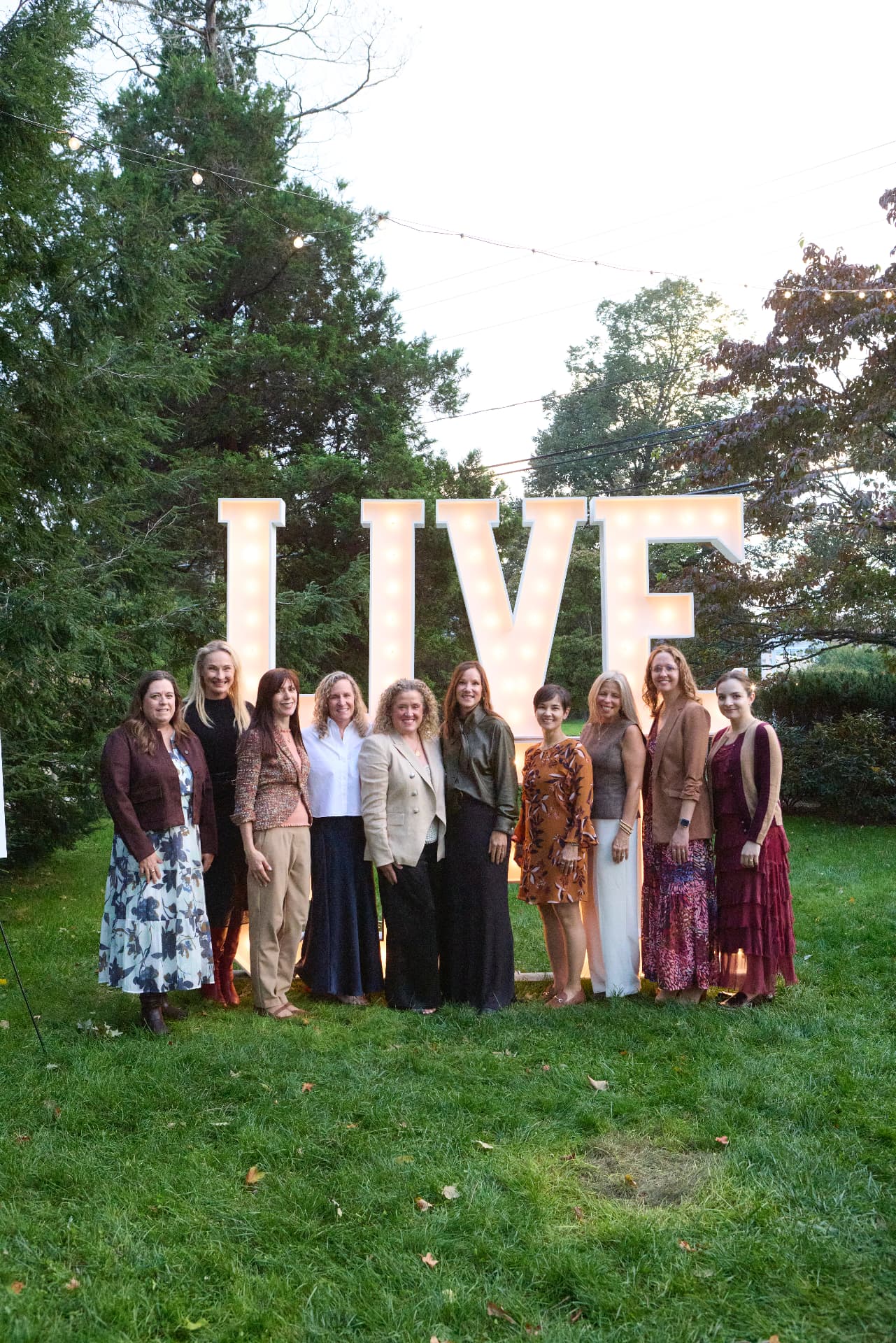 The LiveGirl Advisory Committee in front of the glowing LIVE letters
