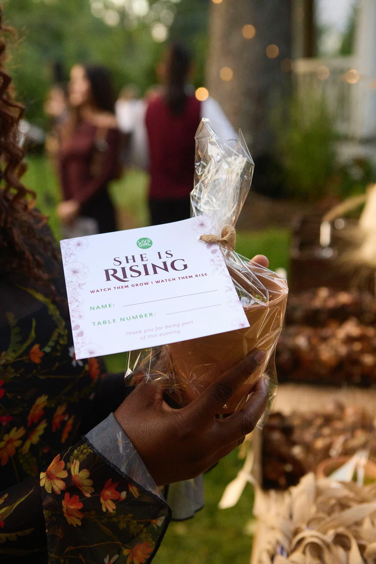 A She Is Rising place card and wrapped welcome gift